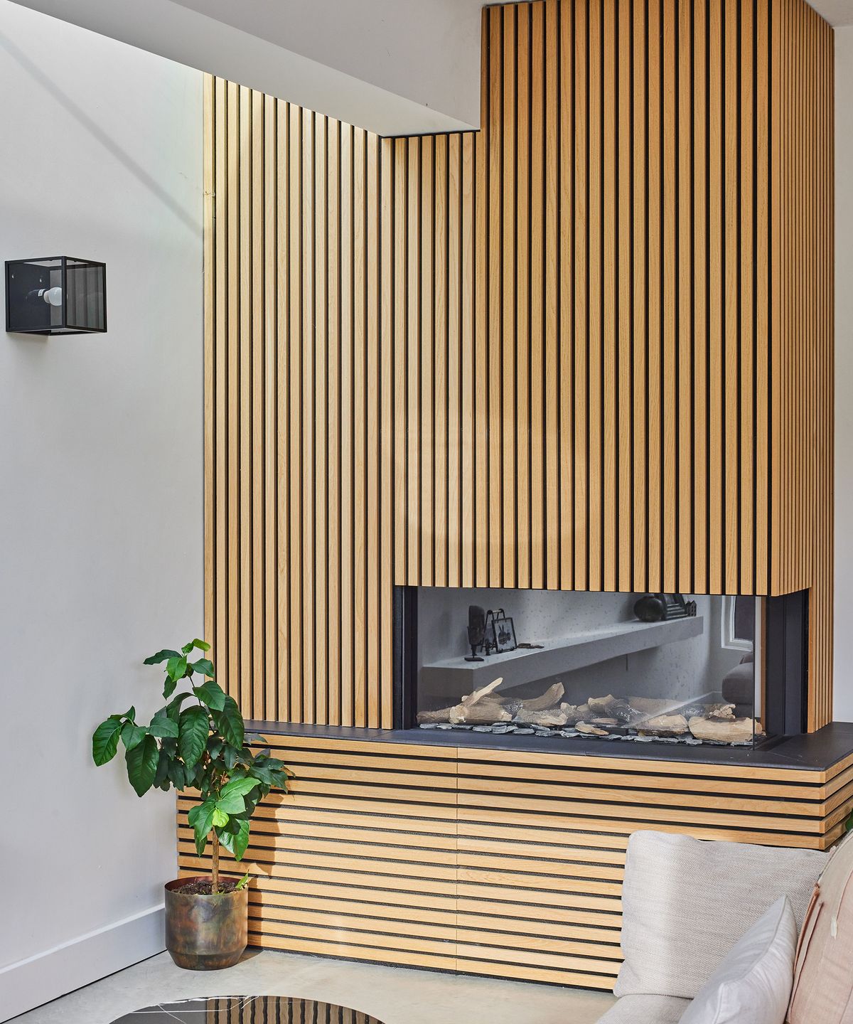 Timber panelling cladding a built in fireplace in a contemporary self build