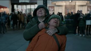 Andy Serkis gleefully holds a man at knifepoint in Piccadilly Circus in Luther: The Fallen Sun.