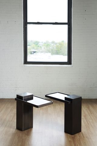 Two side tables shown by a window