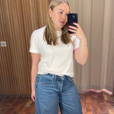 Woman wears white t-shirt and barrel-leg jeans