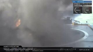 The Falcon 9 first stage comes down on the deck of a robotic "droneship" in a cloud of smoke on June 15, 2016. The landing was not successful, SpaceX representatives said.