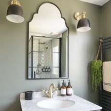 Sage green bathroom with wall sconces