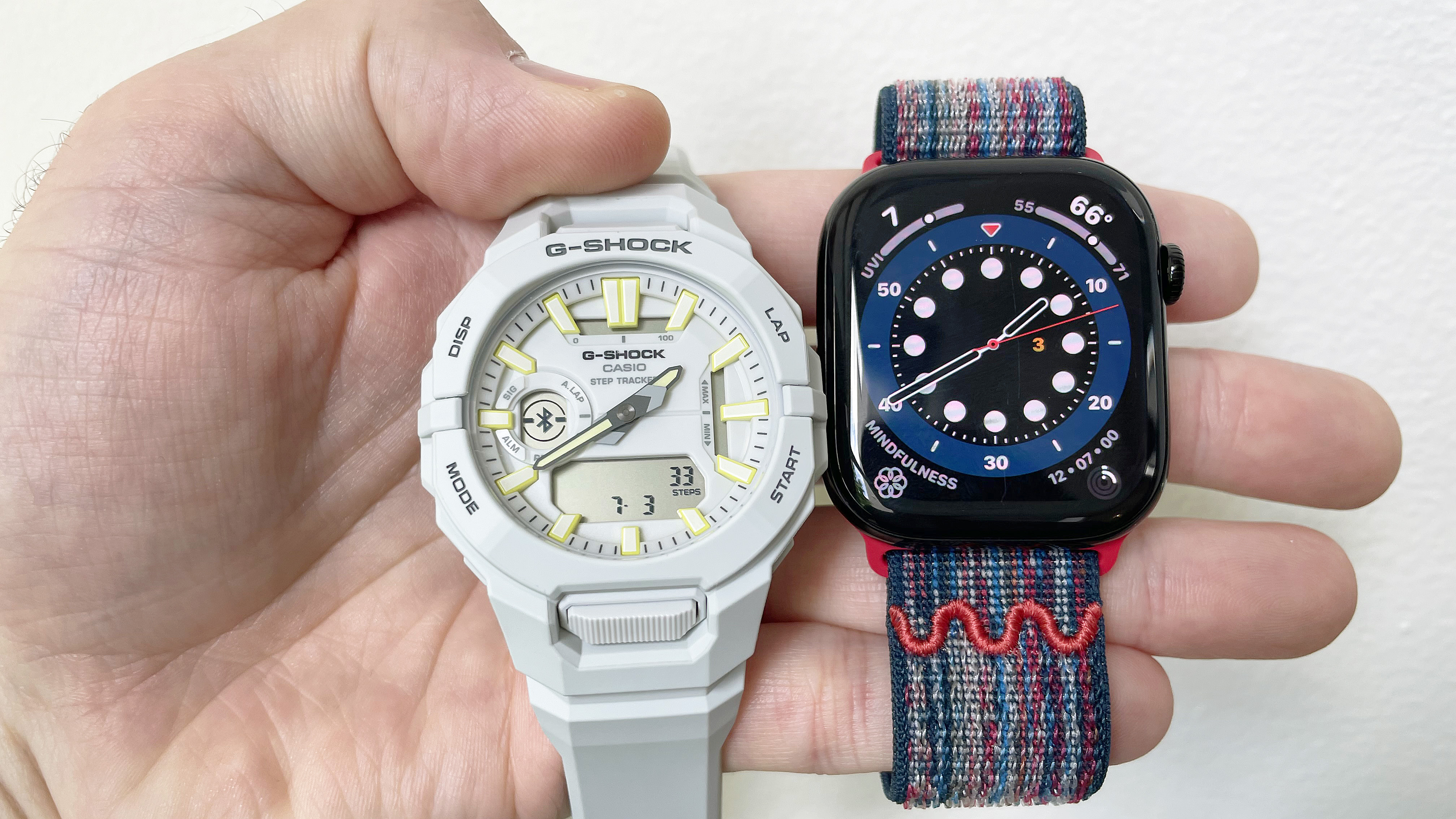 Close-up of the Casio G-Shock Move GBA950 fitness-tracking smartwatch next to the Apple Watch Series 10