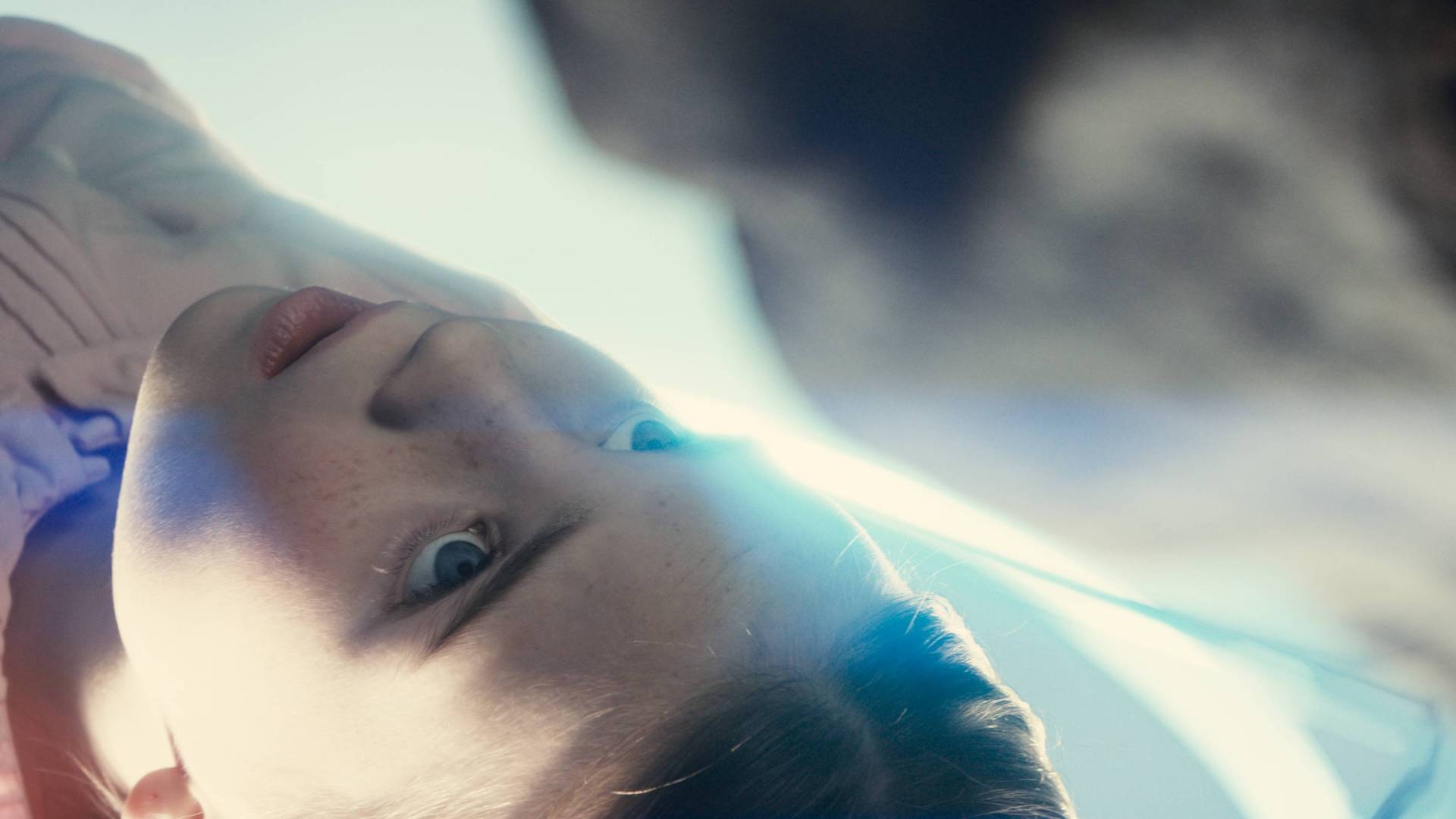 A young girl looking up at an alien in Disclosure Day