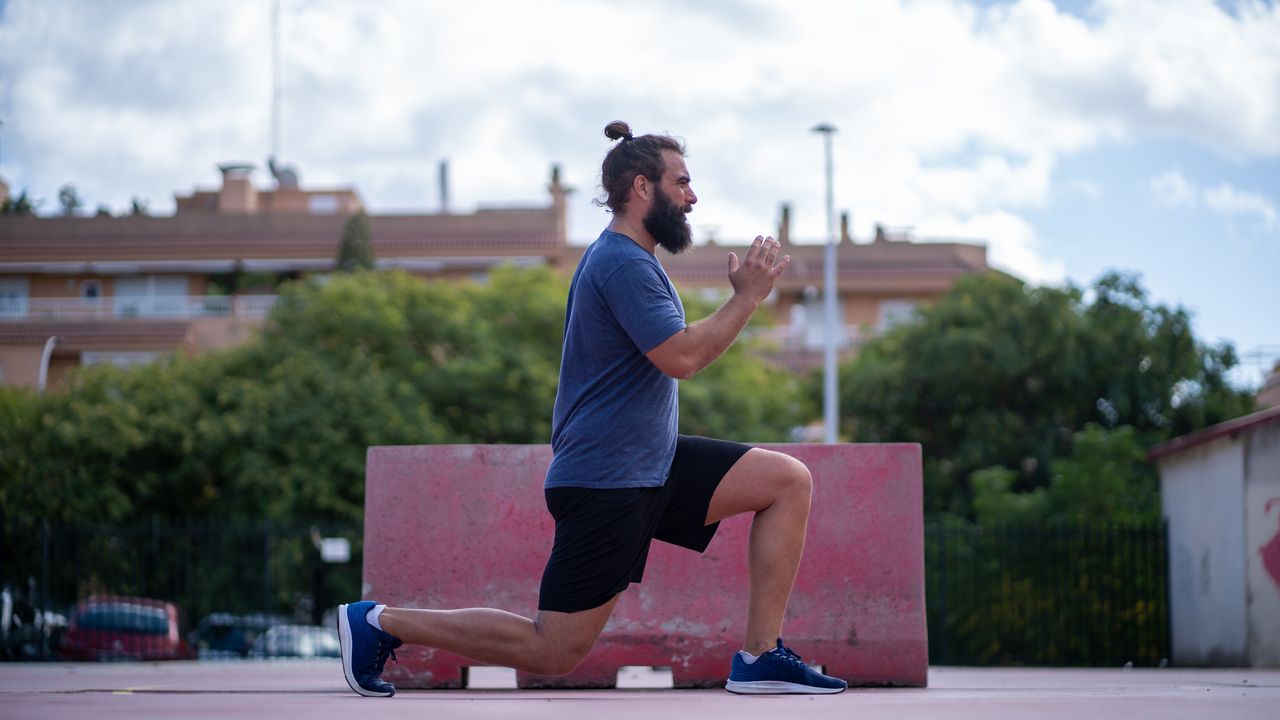 Man performing jumping lunges outside