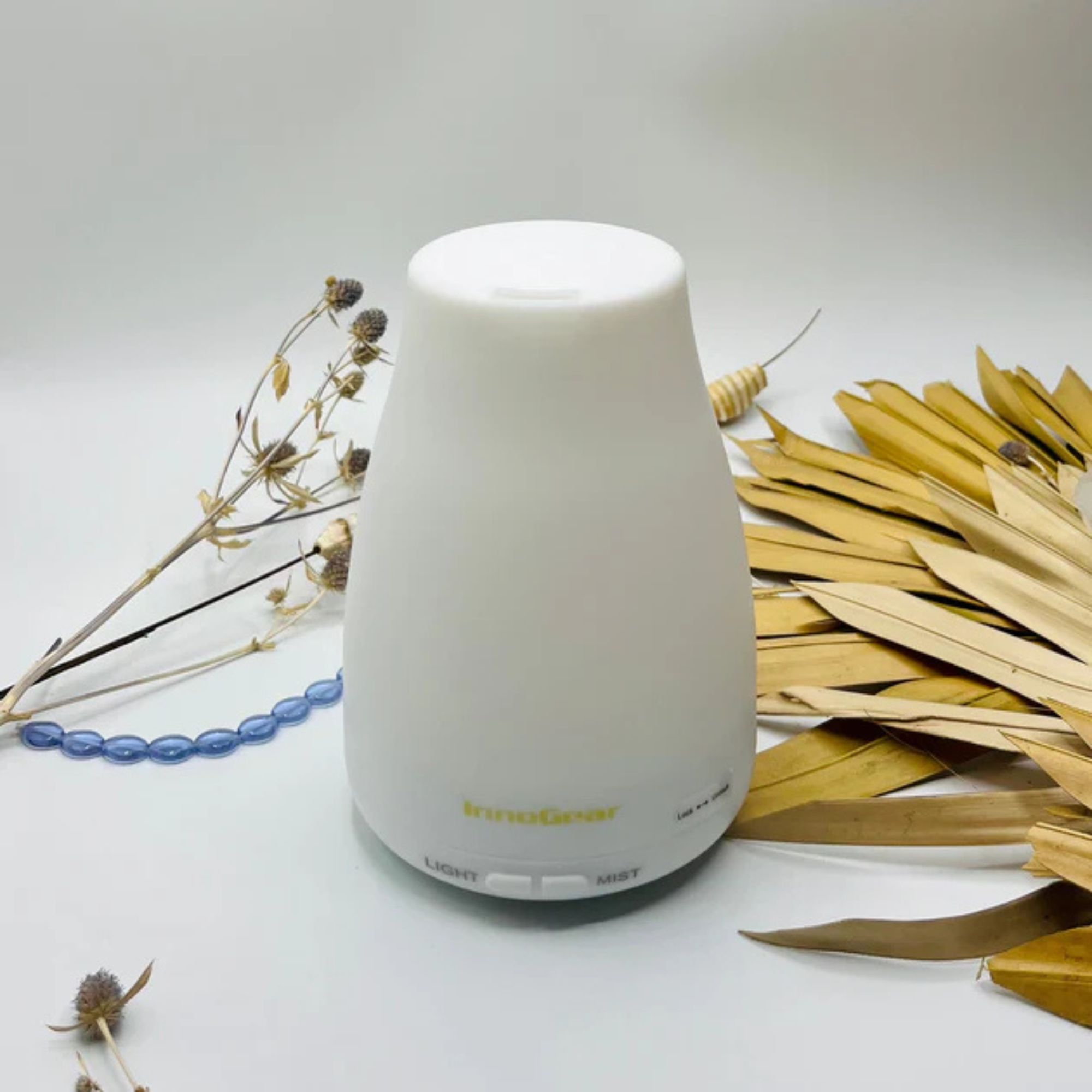 InnoGear Essential Oil Diffuser against a white background strewn with petals.