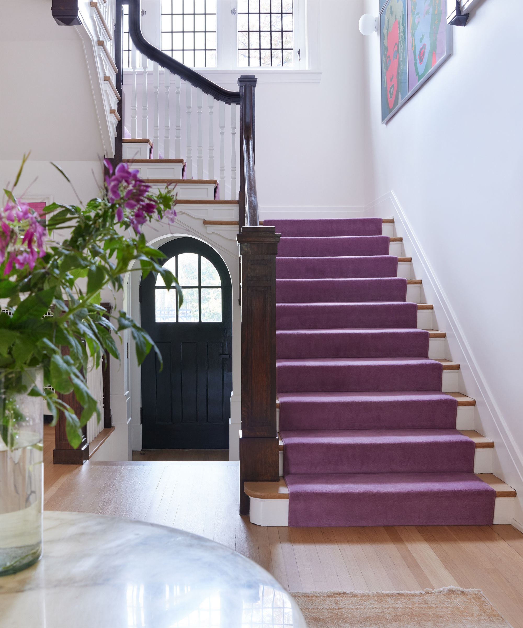 bright entryway with white walls and purple stair runner