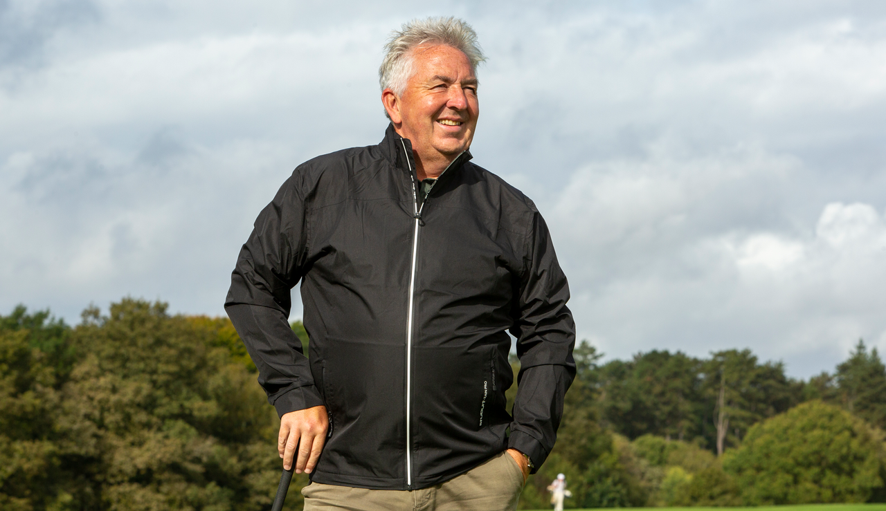 A golfer wears the Stuburt Leaden Lightweight Waterproof Jacket