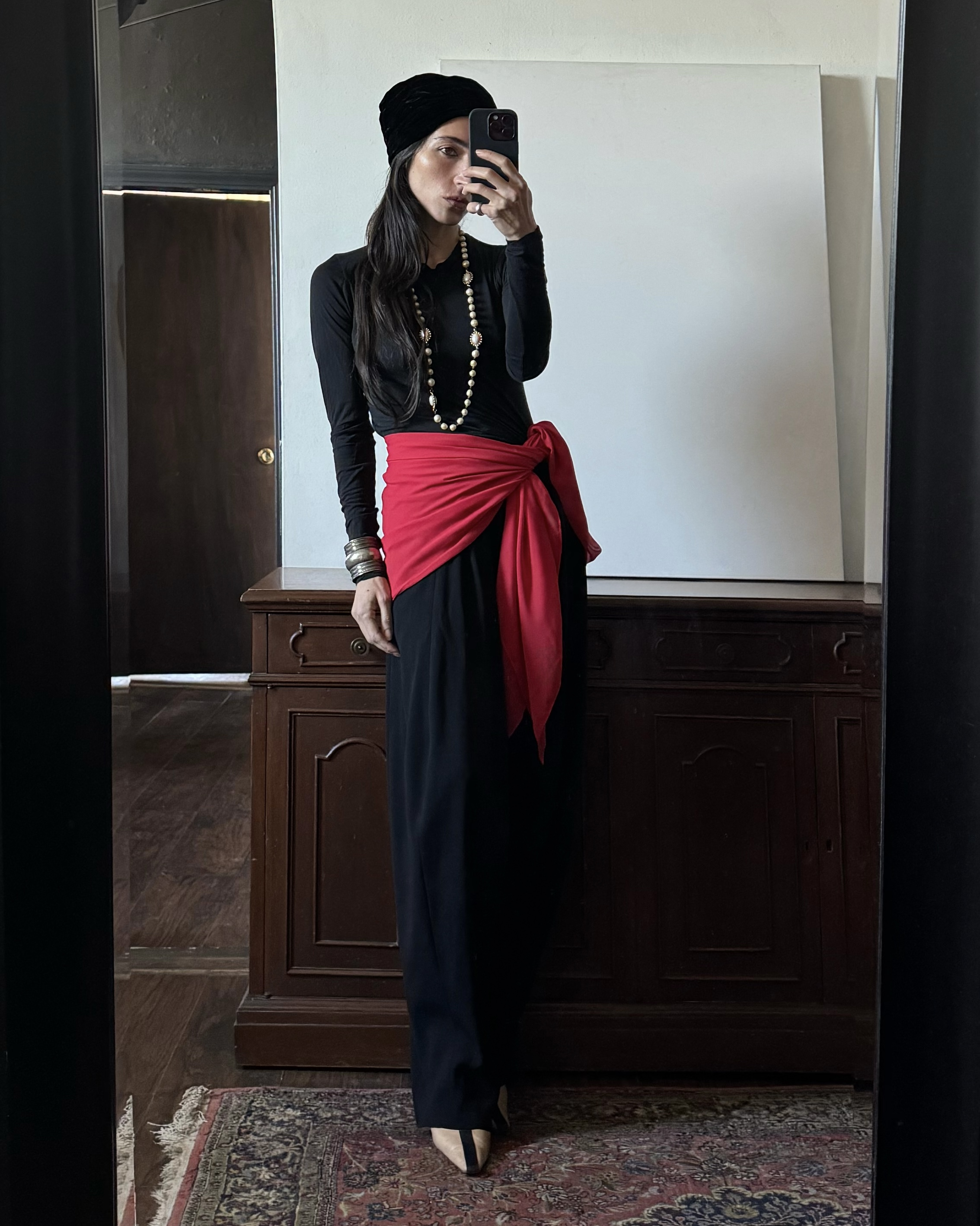 Alexis Badiyi wearing a red sash and a velvet hat