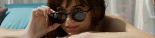 Dakota Johnson looking over her sunglasses in Fifty Shades Freed