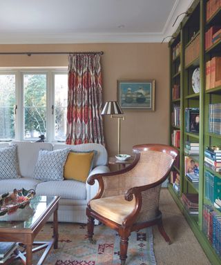 Traditional living toom with rattan accent chair and painted bookcase