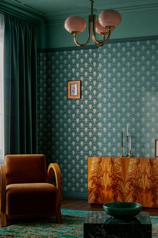 art deco design A vintage inspired living room with green wallpaper decorated with gold art deco patterns