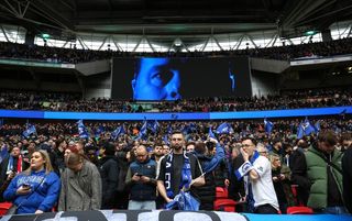 The face of Chelsea manager Mauricio Pochettino appears on the Wembley big screen above the Chelsea fans