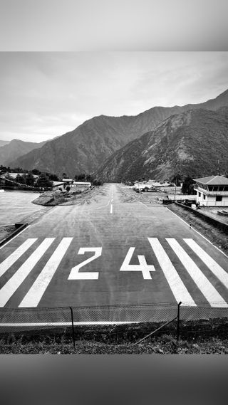 Black and white image, showing a runway with number 24