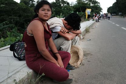Members of the Central American migrant caravan wait along the roadside as theymove to the next town on November 02, 2018 in Donaji, Mexico.