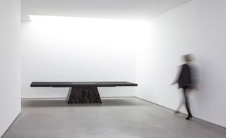 Minimalist table with solid base constructed from petrified wood