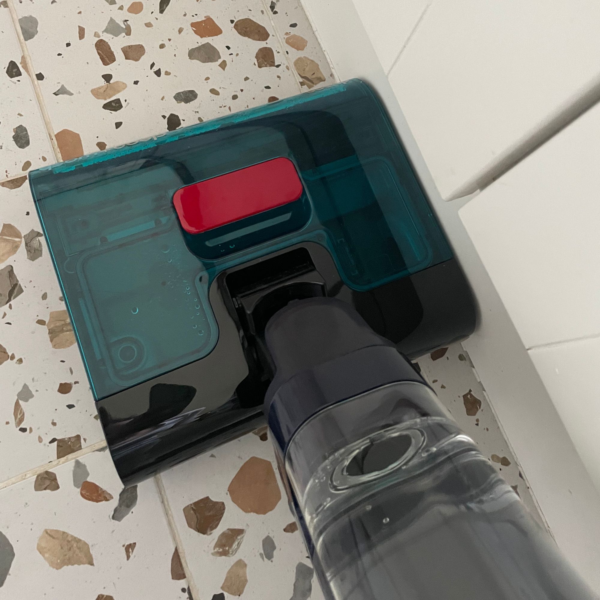 Using Dyson Clean+Wash Hygiene to clean up to baseboards in a kitchen, on terrazzo tiled flooring