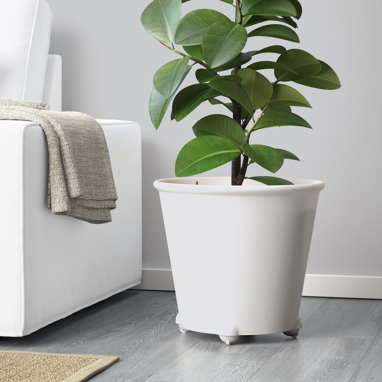 Panci self-watering IKEA PS FEJÖ berwarna putih di samping sofa