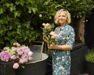 A florist holding cut flowers in her garden