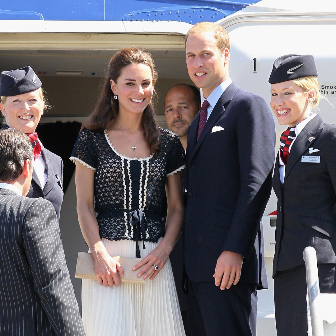 Prince William and Princess Kate standing with flight attendants on a British Airways flight