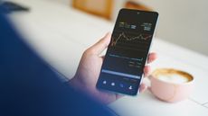 A man checks a stock-trading graph on his smartphone.