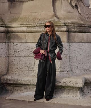 woman in black outfit with burgundy bag