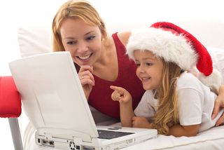 Mother and young daughter shopping online for Christmas.