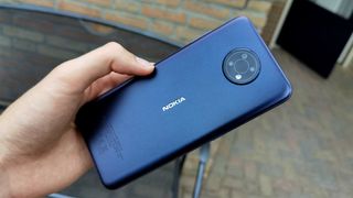 En person som håller i en blå Nokia G10