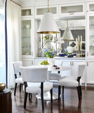 White dining chairs and round table, white lamp