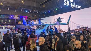 A full-scale model gyrocopter with passengers wearing VR headsets at MWC 2023.