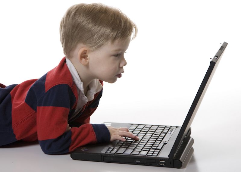 A young boy types on a computer.