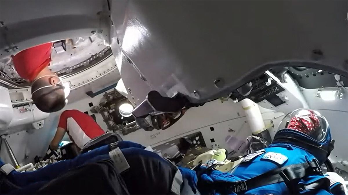 An astronaut enters the Starliner spacecraft for the first time.
