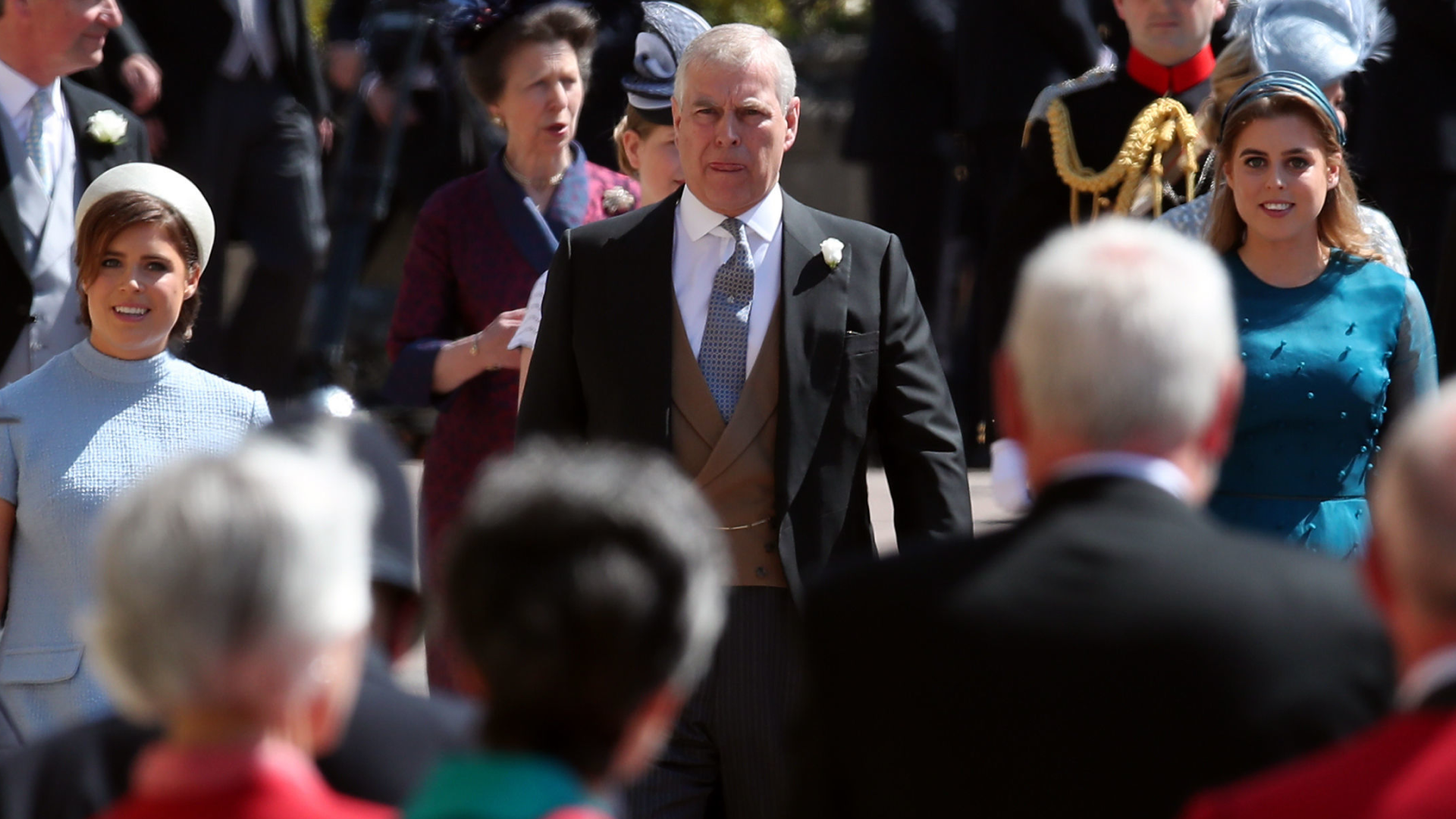 Princess Beatrice, Princess Eugenie and Andrew Mountbatten-Windsor walking in a crowd on the way to Meghan Markle and Prince Harry's wedding