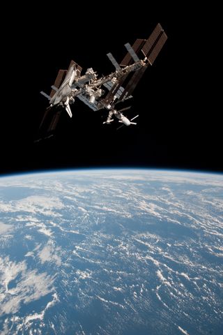 This photo shows the shuttle Endeavour at the International Space Station as both spacecraft soar high above a bright blue Earth. This photo is one of the first-ever views of a NASA shuttle docked at the space station and was taken during Endeavour's fin