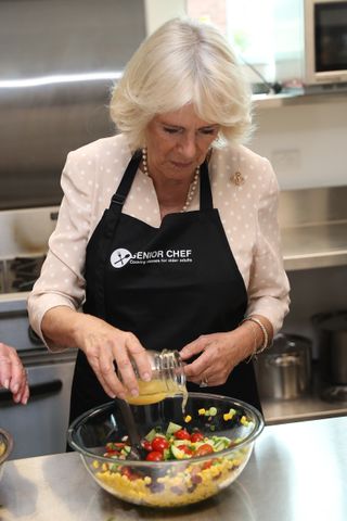 Queen Camilla takes part in a cooking class with the "The Cooks" senior chefs as she attends an Active Elderly engagement at the Salvation Army Centre on November 22, 2019 in Christchurch, New Zealand.