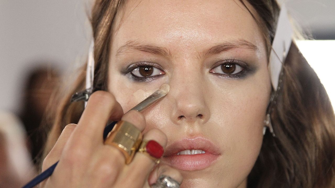 A model gets foundation applied backstage at the Houghton fashion show during MADE Fashion Week fall 2014 at Milk Studios on February 6, 2014 in New York City.