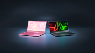 a pink and a black laptop against a dark background