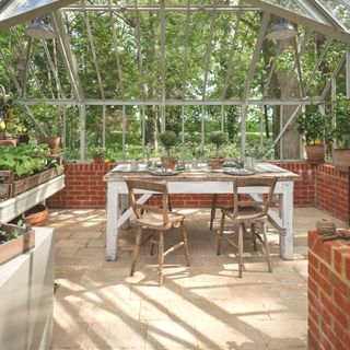 greenhouse with limestone flooring potting area and table and chairs