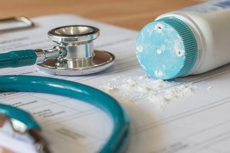 A bottle of talcum powder sits on top of a patient's medical chart.