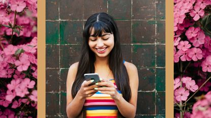 woman in striped tank top outside on the phone smiling with a floral background