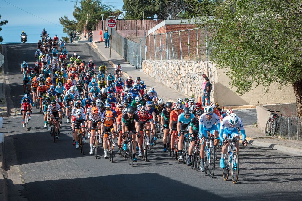 The peloton descends off the hill in the back straight