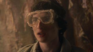 Mike covered in dirt wearing goggles in tunnel in Stranger Things 5 Episode 4