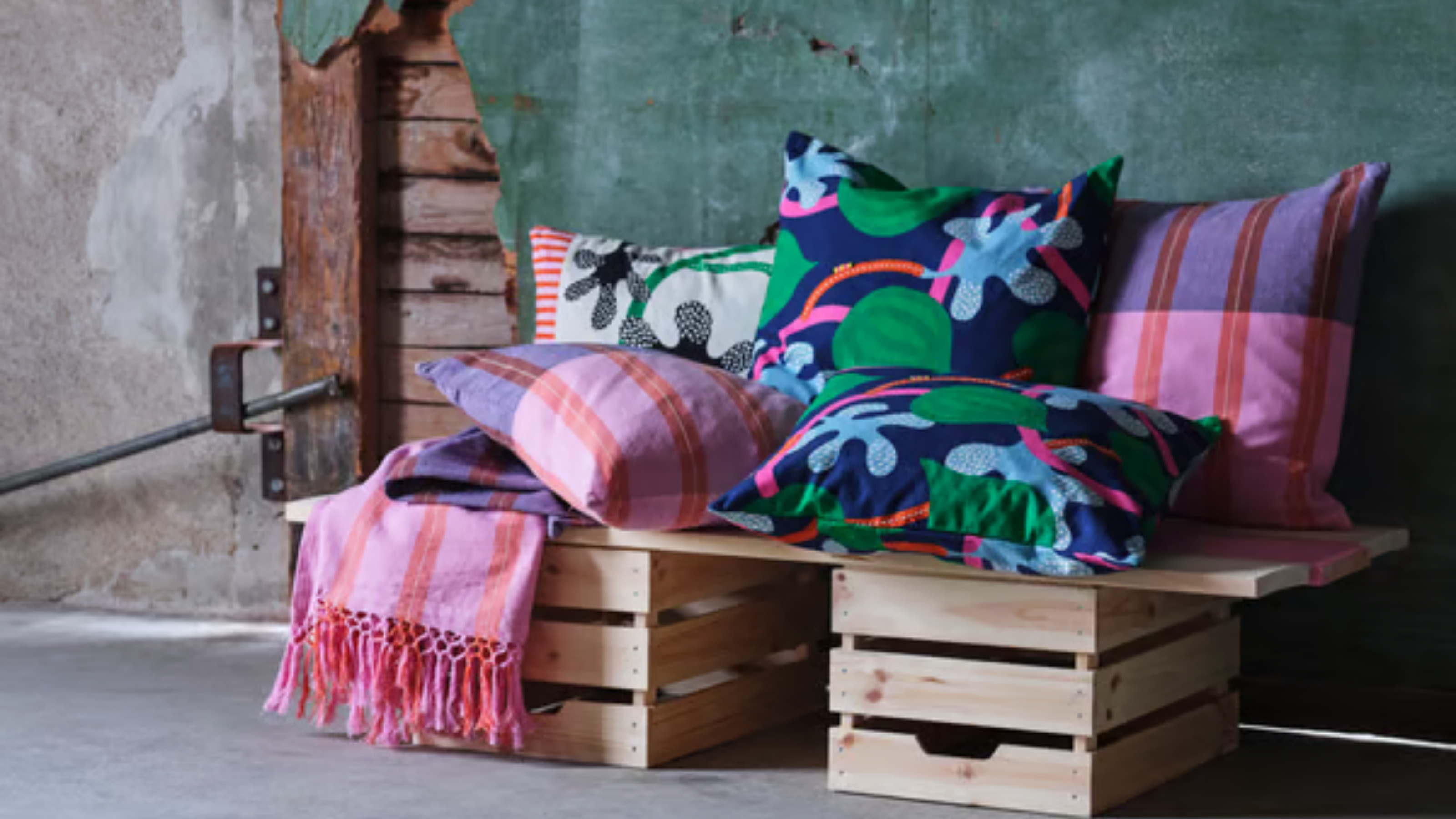 MÄVINN pillows and throws on a wooden crate