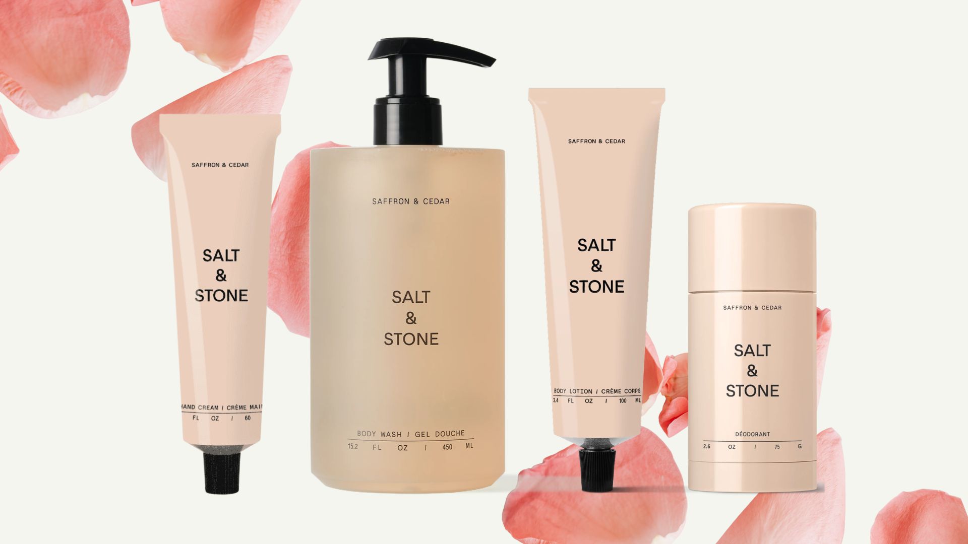Salt &amp; Stone Saffron &amp; Cedar collection on a beige background with pink rose petals