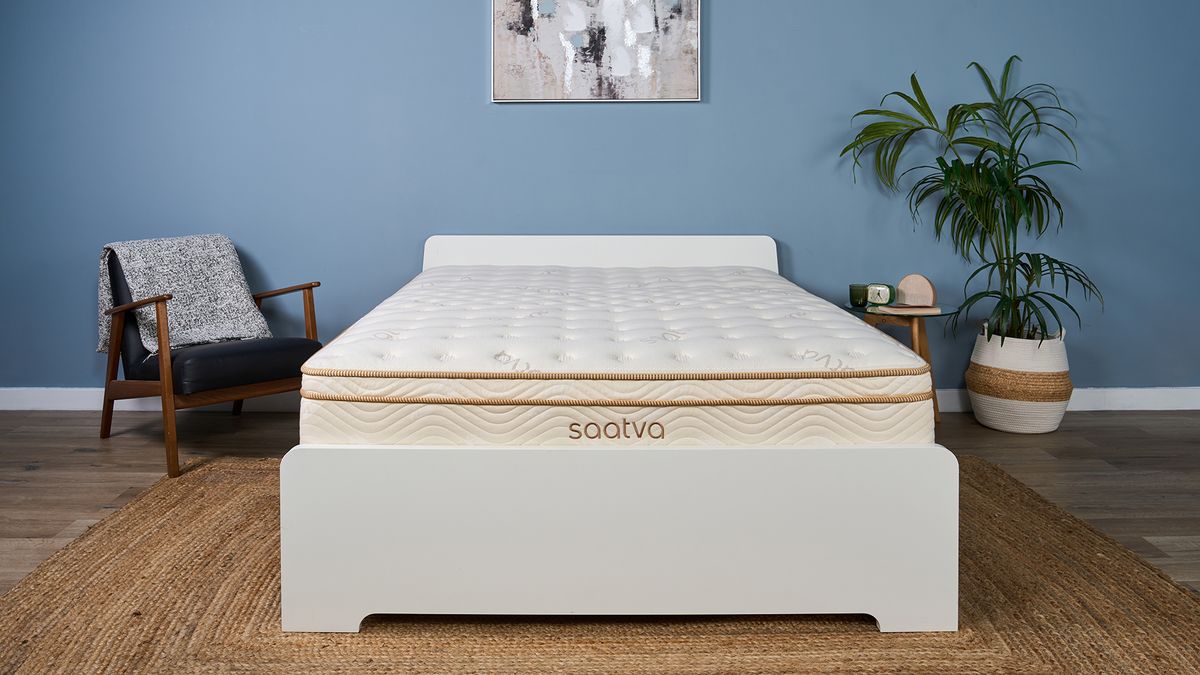The Saatva Classic mattress in our Sleep Studio, decorated like a bedroom