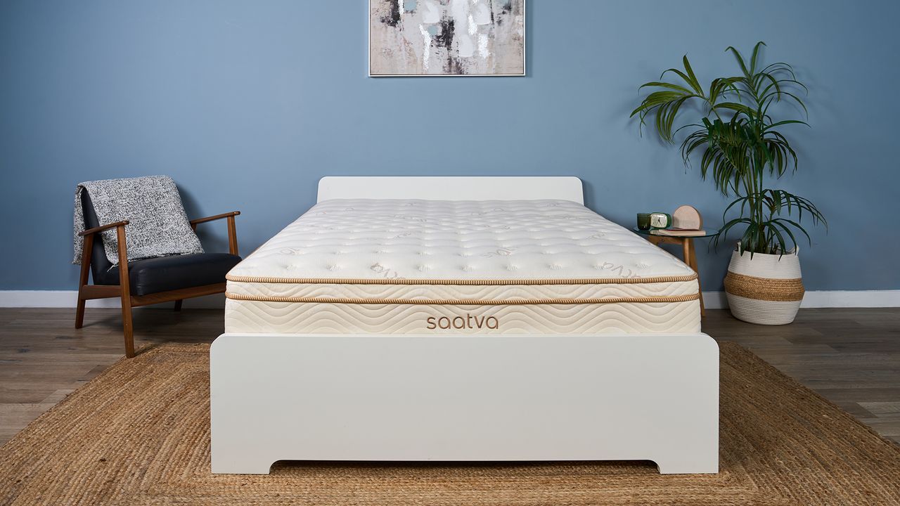The Saatva Classic mattress in our Sleep Studio, decorated like a bedroom