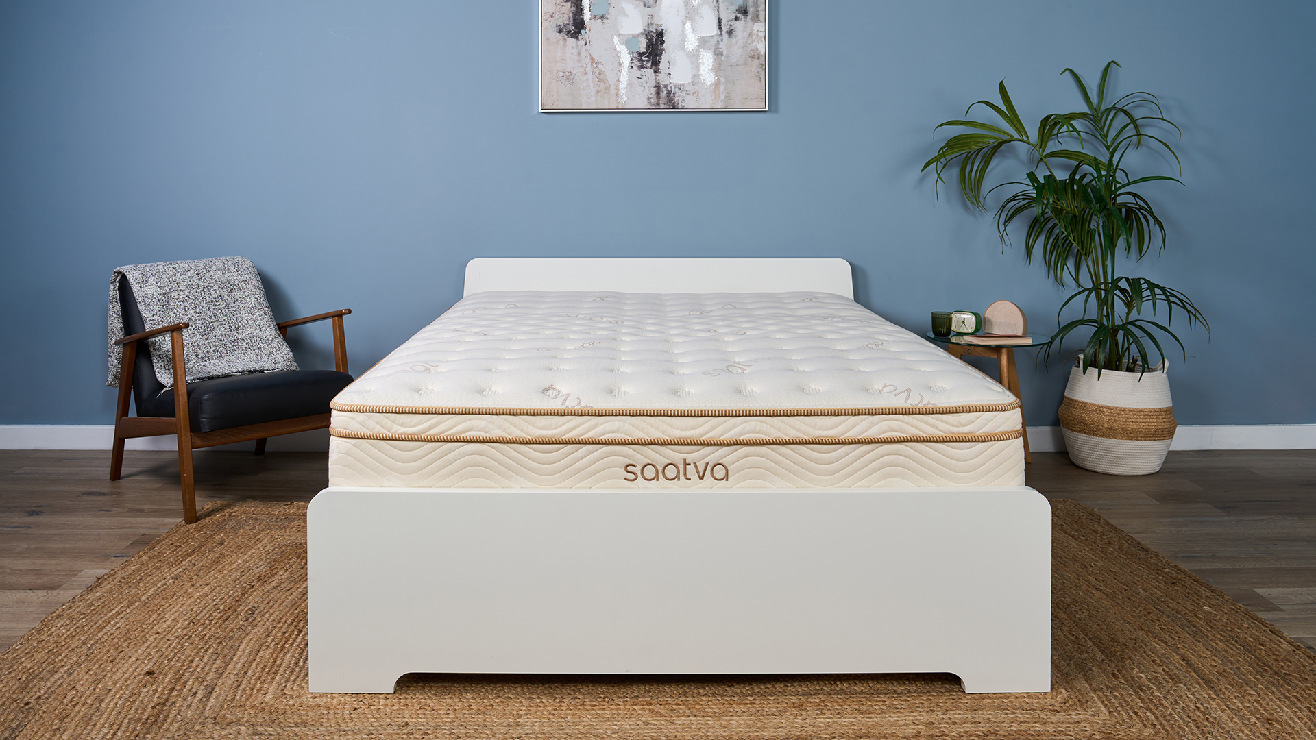 The Saatva Classic mattress in our Sleep Studio, decorated like a bedroom