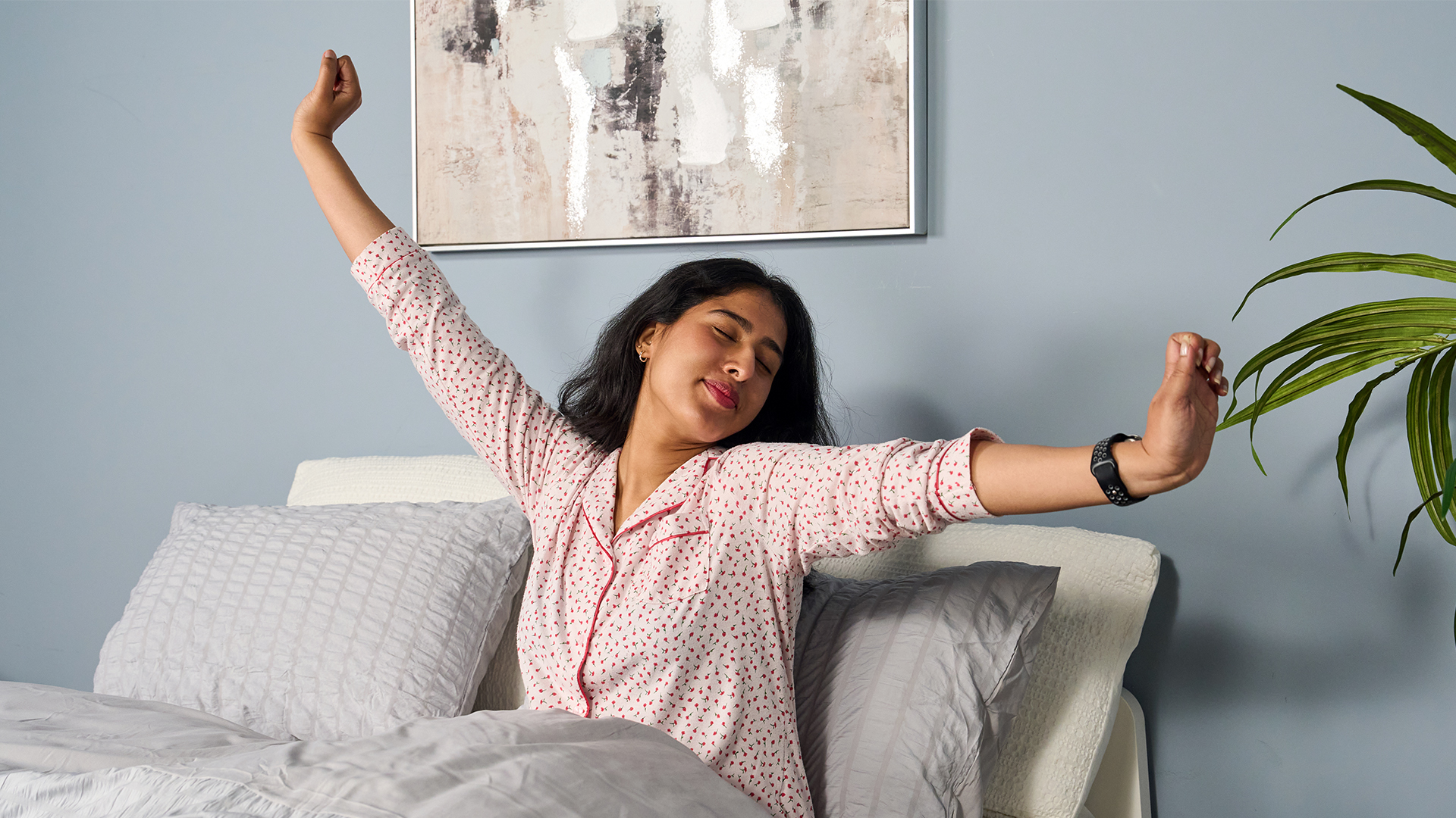 Sleep tester Becky George wakes up in bed and stretches, following a good night's sleep