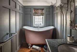 a grey panelled bathroom with a small bath