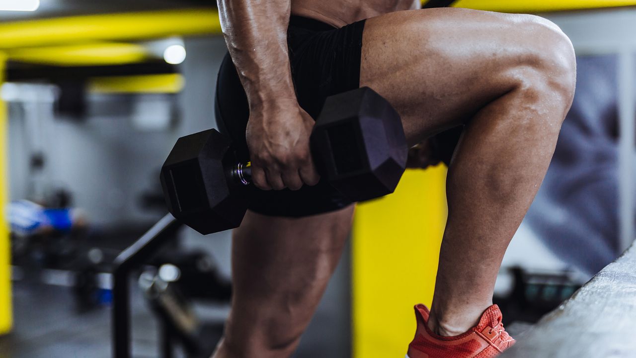 Man exercising in the gym with dumbbells